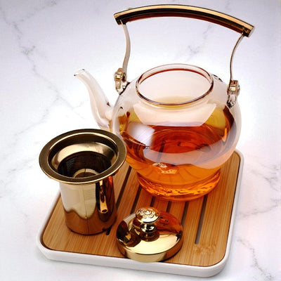 Glas und goldene Teekanne