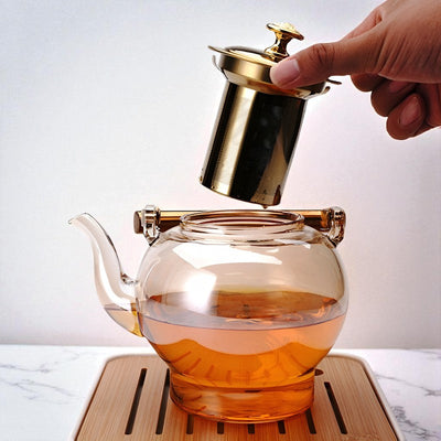 Glas und goldene Teekanne